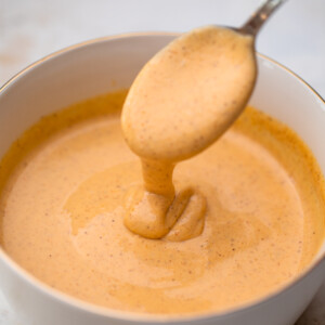 spoon dipping into a white bowl full of yum yum sauce